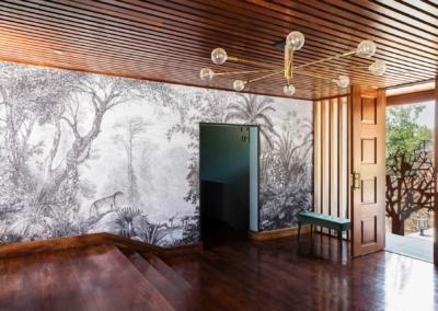 Black and white wall mural, jungle scene, animals. Elements include foliage, leaves, trees, exotic animals. Predominantly shades of black and white. Intricate nature details create contrast against the modern interior decor.