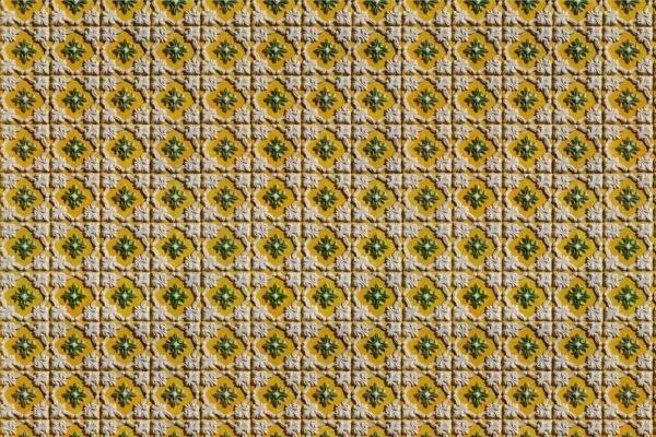 Intricate wallpaper pattern with small, repetitive floral designs on each tile. Yellow background, green and orange accents, bordered by raised white grout. Symmetrical and textured surface designed to bring a "Smile Today.