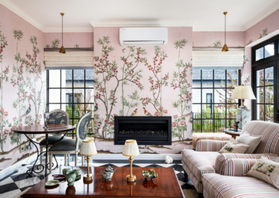 Floral pink wallpaper with delicate blossoms and greenery. Shades of blush, rose, and soft green create a sophisticated yet vibrant backdrop. Peonies, roses, and intricate leaf patterns bring elegance to the modern living room setting. Perfect for adding a stylish touch to any interior design portfolio.