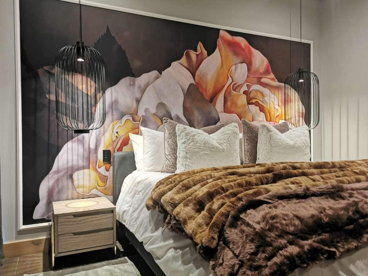A small bedroom with a large wall mural to give space and depth
