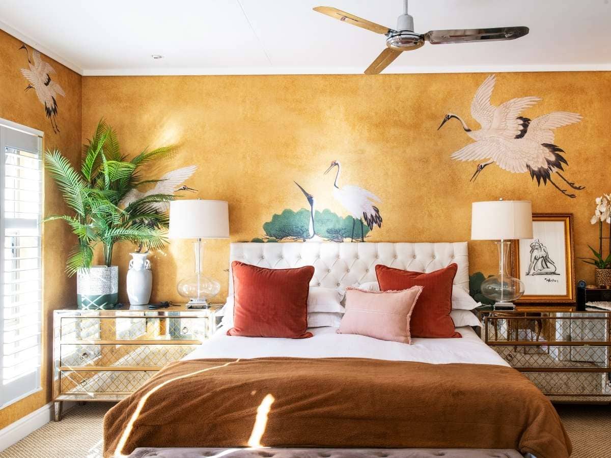A small bedroom with stork inspired yellow wallpaper