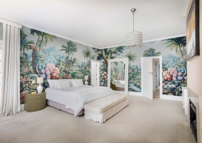 A vibrant tropical mural covers the walls, showcasing lush green plants, colorful flowers in shades of pink, red, and yellow, and exotic foliage. The rich palette brings nature indoors with detailed illustrations of leaves and blossoms intertwined harmoniously. Perfect for adding a burst of color and life to any room.