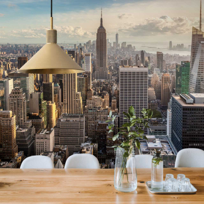 Wallpaper featuring an elegant cityscape design with intricate skyscrapers, including the Empire State Building. Key elements are detailed buildings in shades of gray and white, subtle tonal variations representing windows and architectural features. Touches of soft blue to mimic the sky and muted hues for a sophisticated urban look. Delicate outlines and shading give a three-dimensional effect that complements modern decor settings.
