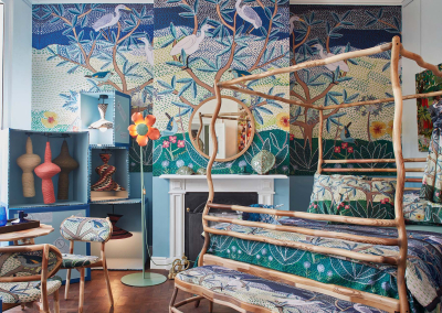 The nature-themed mural wallpaper features colorful birds and trees, creating a vibrant backdrop. The design incorporates various shades of green, blue, and brown, with pops of red and yellow from the birds. This lively blend of elements could inspire your portfolio with its dynamic and engaging aesthetic.