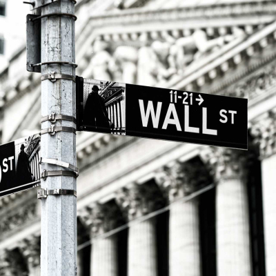 Wallpaper features: Black and white street signs for Wall Street and Broad Street with directional arrows. Background includes the New York Stock Exchange building. Predominant elements are the iconic signage, architecture, and a bustling city atmosphere, symbolizing financial activity and continuous motion towards success. Key colors: black, white.