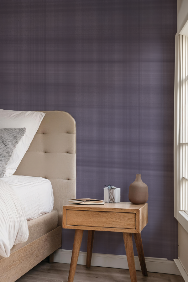 The wallpaper in the minimalist bedroom features a rich **purple texture** that adds depth and character to the space. The textured design includes subtle **swirls and patterns**, creating an engaging visual effect without overwhelming the room. This deep purple hue contrasts beautifully with the neutral tones of the beige upholstered bed, enhancing the earthed charm of the environment.