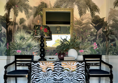 The wallpaper features a lush, tropical theme with vibrant green palm trees and plants. It's perfect for creating a natural, exotic ambiance. Key elements include detailed leaf patterns in varying shades of green and hints of earthy browns and soft yellows, giving it a lively yet sophisticated look.