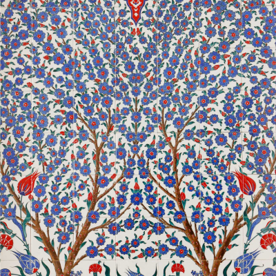Intricate tile design, symmetrical floral patterns, blue motifs, red motifs, green motifs, stylized trees, dense clusters of flowers and leaves, vibrant decorative layout.