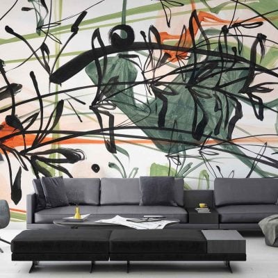 Abstract mural wallpaper featuring bold black, green, and red brush strokes creates a vibrant backdrop in the living room. The mural's dynamic design enhances the minimalist decor, complementing cozy pillows and a blanket with its striking colors.