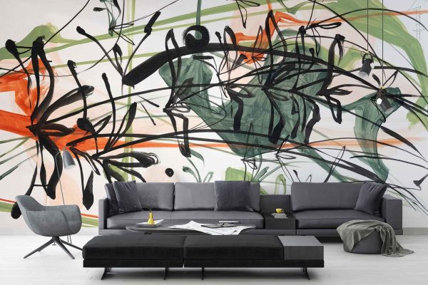 Abstract mural wallpaper featuring bold black, green, and red brush strokes creates a vibrant backdrop in the living room. The mural's dynamic design enhances the minimalist decor, complementing cozy pillows and a blanket with its striking colors.
