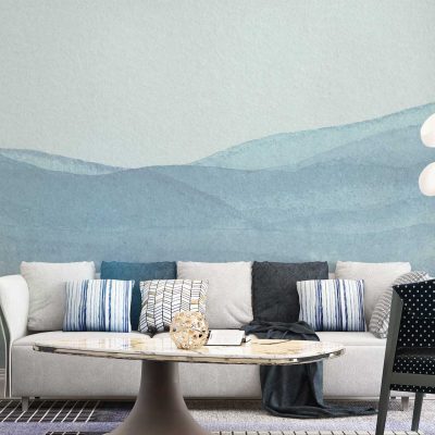 The wallpaper in the modern minimalist living room features a mural of layered blue hills. It incorporates various shades of blue, ranging from deep navy to soft azure, creating a serene gradient effect. The design emphasizes organic shapes with gentle curves and smooth transitions between layers, adding depth and tranquility to the space.