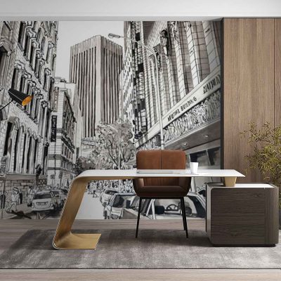 Large wall mural wallpaper depicts Adderley Street with tall city buildings, urban architecture, and street scenes. Features grayscale tones with accents of brown, beige, and hints of blue sky. Elements include detailed facades, windows, street lamps, and subtle shadows for a realistic cityscape look.