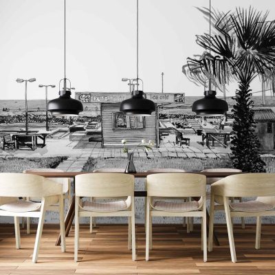 Black-and-white wall mural featuring a beachside café scene: palm trees, lounge chairs, café tables and chairs, with the ocean and sky in the background. Monochrome palette—shades of black, white, and gray—creates a serene coastal atmosphere.
