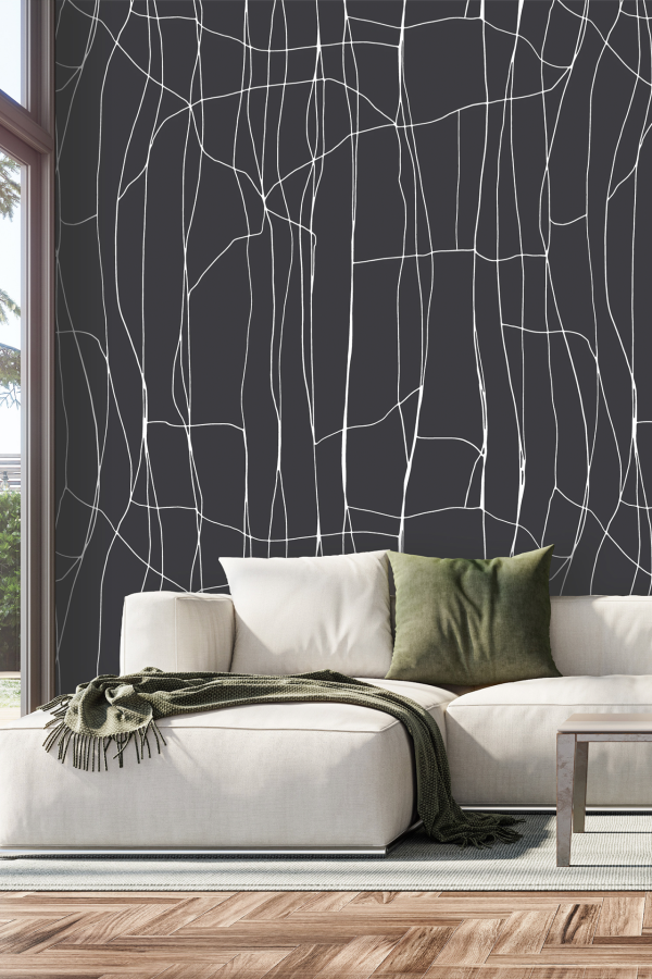 Abstract wallpaper with a dark background and bold, white line patterns inspired by traditional saree designs; the lines are flowing and intricate, creating a striking contrast against the deep wall color. The design features geometric curves and looping shapes, offering an elegant, modern interpretation of textile art in monochrome.