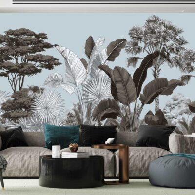 The wallpaper features a detailed mural of tropical trees and leaves in muted tones. Elements include palm fronds, banana leaves, and exotic foliage with shades of sage green, dusty teal, taupe, soft gray, and subtle ivory accents. The design is intricate and oversized for a dramatic yet sophisticated backdrop in modern interiors.