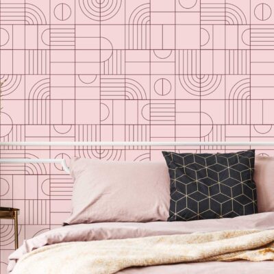 Geometric-patterned pink wallpaper features bold lines, blush and rose tones, and subtle accents of gold. The modern design adds dimension with overlapping shapes—diamonds, triangles, and hexagons—in varying shades of pink. Perfect for a statement wall in contemporary bedrooms seeking a chic, on-trend look.